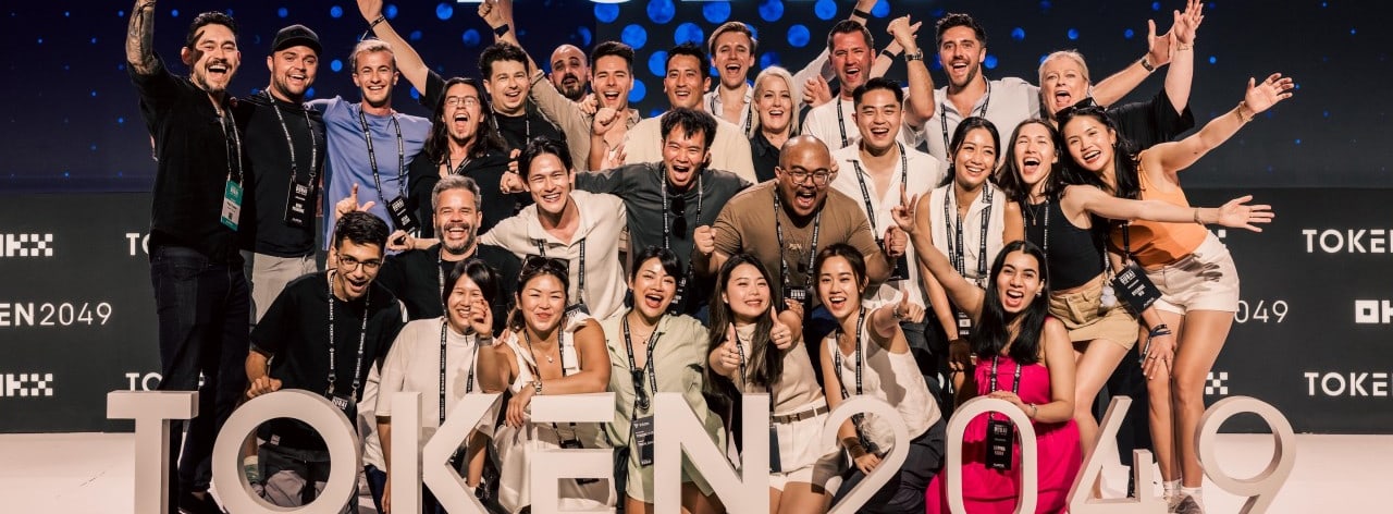 The TOKEN2049 team on stage in front of the TOKEN2049 letters